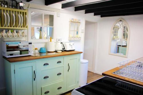 a kitchen with blue cabinets and a counter top at Romantic* Castle on the Hill Cottage *Framlingham in Framlingham