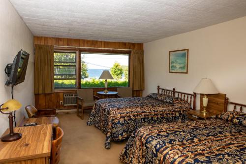 ein Hotelzimmer mit 2 Betten und einem Fenster in der Unterkunft Hillside Inn in Ellison Bay