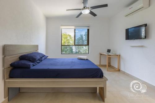a bedroom with a bed and a ceiling fan at Villa Ana Lucía. in Playa del Carmen