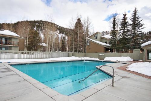 a swimming pool in a yard with snow on the ground at 1100 Flying Dutchman condo in Keystone