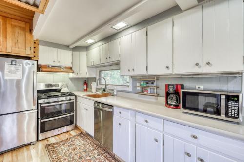 a kitchen with white cabinets and stainless steel appliances at Jay Chalet in Jay
