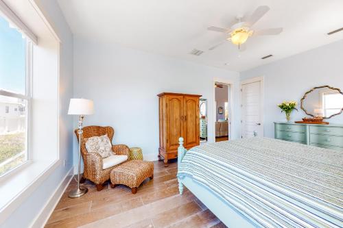 a bedroom with a bed and a chair and a window at Windmark - Sunset by the Bay in Highland View