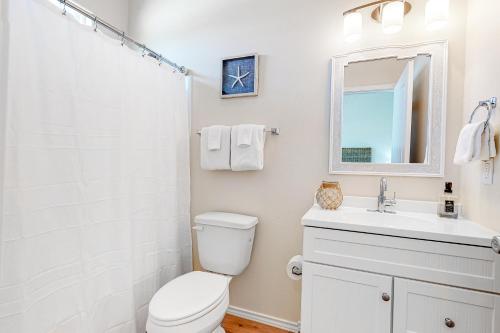 a white bathroom with a toilet and a sink at Sunrise Retreat in Rockport