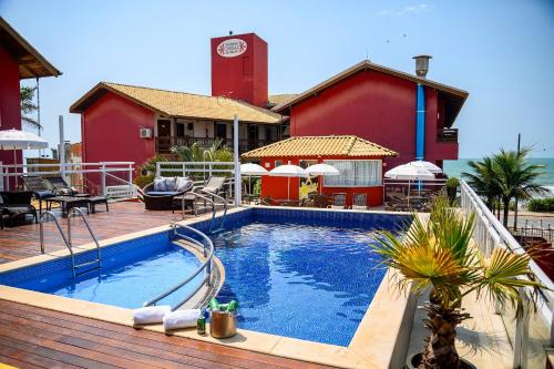 a swimming pool in front of a building with a clock tower at Pousada Ondas da Brava in Itajaí