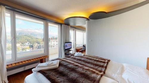 a bedroom with a bed and a large window at Abitaziun Au Reduit 404 - St Moritz in St. Moritz