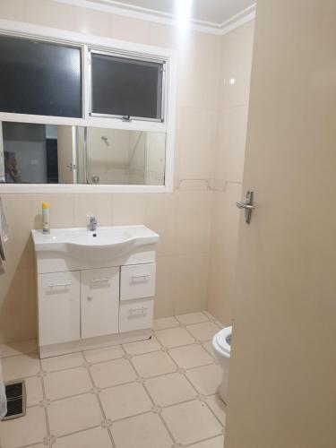 a white bathroom with a sink and a toilet at Homestay near Dandenong Plaza in Dandenong