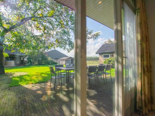a sliding glass door of a patio with a table and chairs at By Romme in Westelbeers