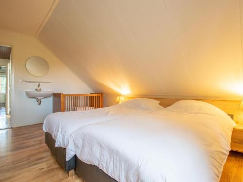 a bedroom with a large white bed and a sink at By Romme in Westelbeers