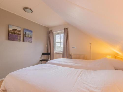 a bedroom with two beds and a window at By Romme in Westelbeers