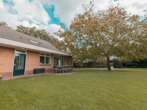 a house with a tree in the yard at By Romme in Westelbeers