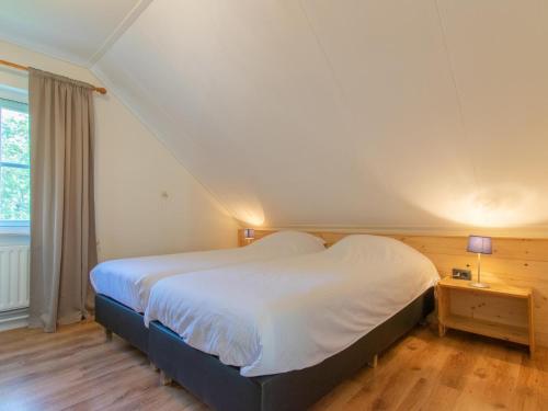 a bedroom with a large bed with white sheets at By Romme in Westelbeers