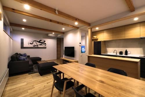 a living room with a dining table and a kitchen at Furano Sanso in Furano