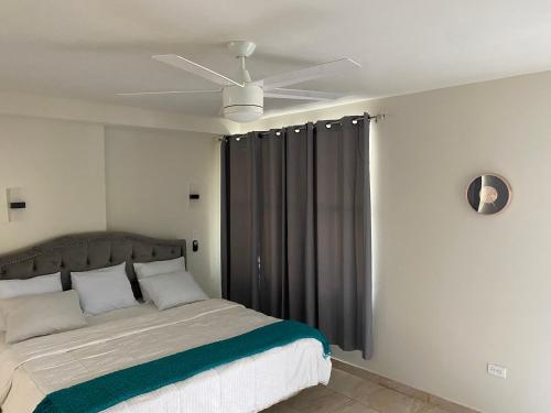een slaapkamer met een bed en een plafondventilator bij Mountain View Hotel and Bar Restaurant in Cap-Haïtien