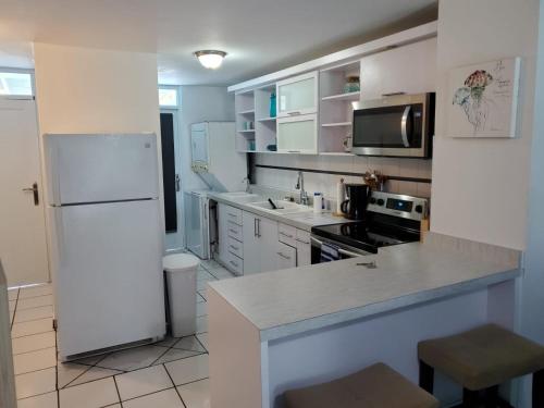 eine Küche mit weißen Geräten und einem weißen Kühlschrank in der Unterkunft Dorado Beach Condo in Dorado