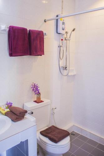 a bathroom with a shower and a toilet and a sink at People Place Classic Hotel SHA Extra Plus in Chiang Mai