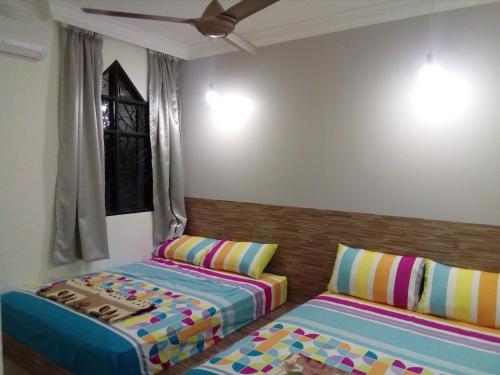 um quarto com 2 camas e uma ventoinha de tecto em Fastbook Sun Moon City Home 12Pax em Ayer Itam