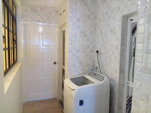 a washer and dryer in a room with a door at Fastbook Sun Moon City Home 12Pax in Ayer Itam