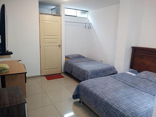 um quarto de hotel com duas camas e uma porta em Peruvian Family Hostal Miraflores em Lima