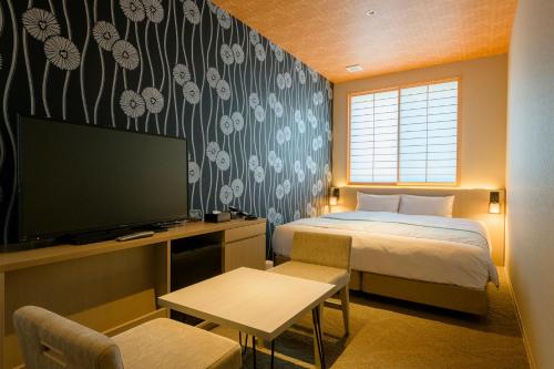 ein Hotelzimmer mit einem Bett, einem TV und einem Schlafzimmer in der Unterkunft Tosei Hotel Cocone Kamakura in Kamakura