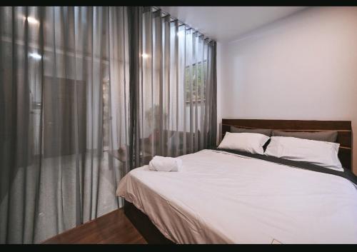 a bedroom with a large bed and a window at Qhome in Ho Chi Minh City