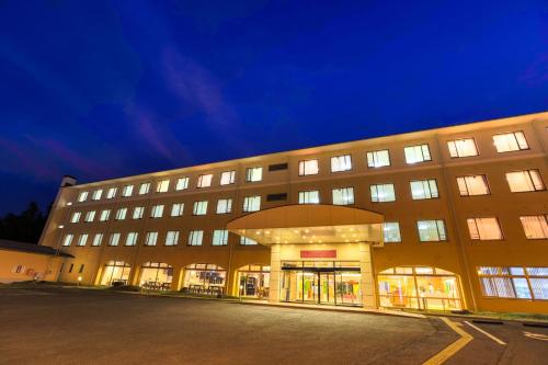a large building with many windows at night at Fuji Matsuzono Hotel in Yamanakako