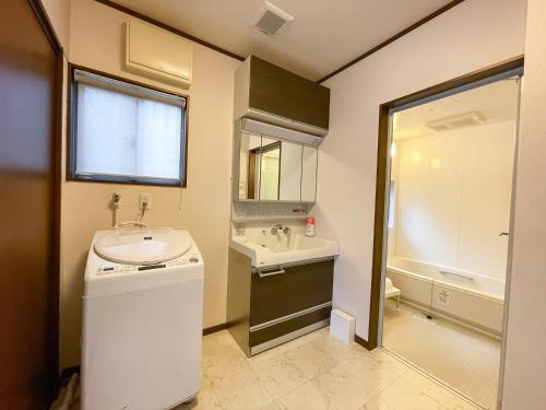 ein Badezimmer mit einem Waschbecken, einem WC und einem Spiegel in der Unterkunft Tiz wan 中田あわじ in Awaji