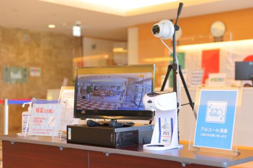 a desk with a computer monitor and a lamp on it at Fuji Matsuzono Hotel in Yamanakako