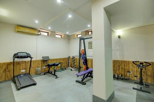 a gym with several exercise equipment in a room at FabHotel Phoenix Hospitality Near DLF Cyber Hub & Metro, Gurugram in Gurgaon