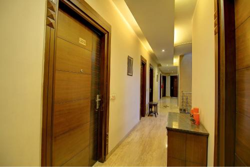 a hallway with a wooden door and a hallway with a table at FabHotel Phoenix Hospitality in Gurgaon