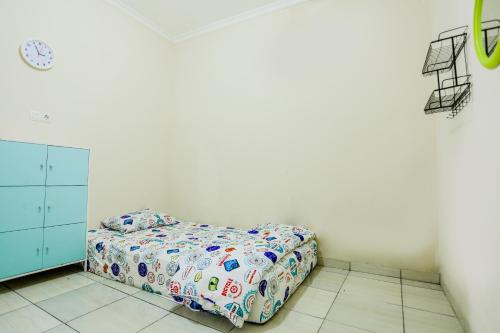 a bedroom with a bed in a white room at OMAMAE HOMESTAY PAGARALAM in Pagaralam