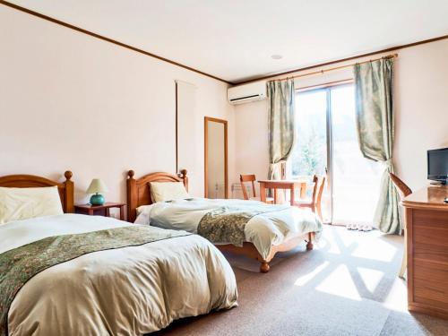 a bedroom with two beds and a window at Mantenbo in Hachijo