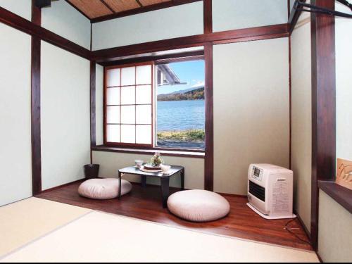 a room with a window with a table and a microwave at Guest House Zen in Yamanakako