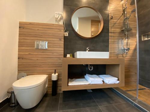 La salle de bains est pourvue de toilettes, d'un lavabo et d'un miroir. dans l'établissement CoolKush Boutique, à Constanţa
