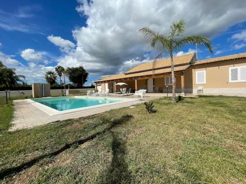 a house with a swimming pool in a yard at Villa Nunzia con piscina, sauna e idromassaggio. in Floridia
