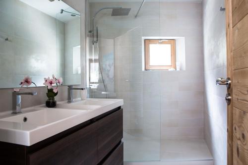 een witte badkamer met een wastafel en een douche bij Le Beausite C Apartment - Chamonix All Year in Chamonix-Mont-Blanc