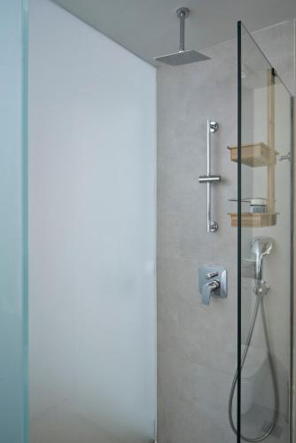 a bathroom with a shower with a glass door at Ilisia Park Contemporary 2BD Condo in Athens