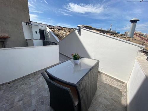 a white balcony with a table and chairs on a roof at La Piccola Formica Charme Rooms in Palermo