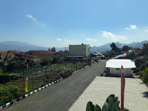 an empty road in a village with a white tent at Maulana Hills Syariah Hotel in Lembang