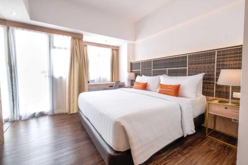 Ένα ή περισσότερα κρεβάτια σε δωμάτιο στο Bigland Bogor Hotel Powered by Archipelago
