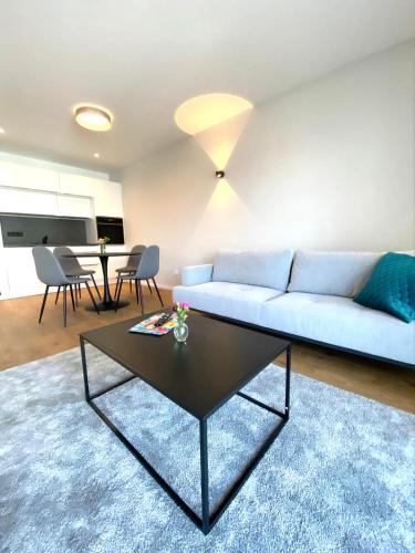 a living room with a blue couch and a table at Motel Inn Simbach in Simbach am Inn