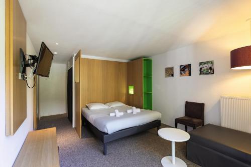 a hotel room with a bed and a tv at Belambra Clubs Gourette - Lou Sarri in Gourette