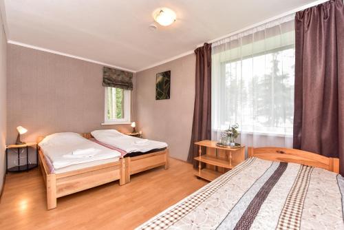 a bedroom with two beds and a window at Svečių namai Banga in Paplatelė