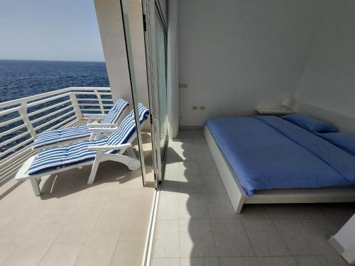 a balcony with a bed and chairs on a cruise ship at Love boat deluxe experience in Callao Salvaje