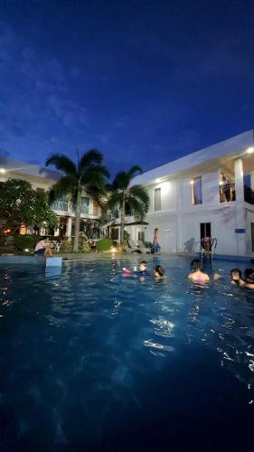 a group of people in a swimming pool at night at A Villas Resort & Restaurant in Zamboanguita