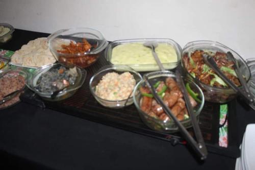 a table with many different types of food in plastic containers at Nogixa Lodge in Umzimkulu
