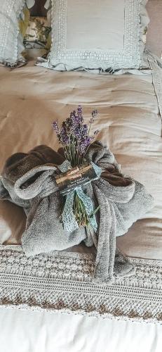 a blanket and a vase of flowers on a bed at Hoeve Westdijk in Oostkamp