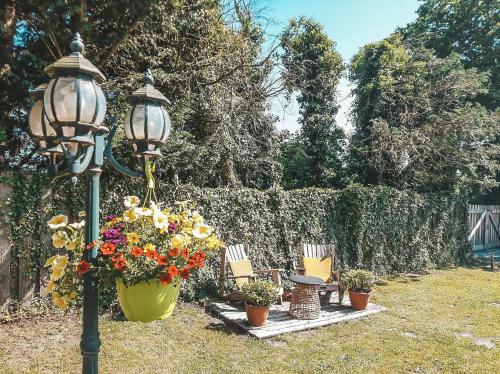 a street light with chairs and flowers next to a fence at Hoeve Westdijk in Oostkamp