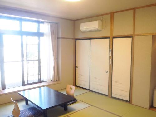 a room with a table and a large window at Oyado Hachibei in Takayama