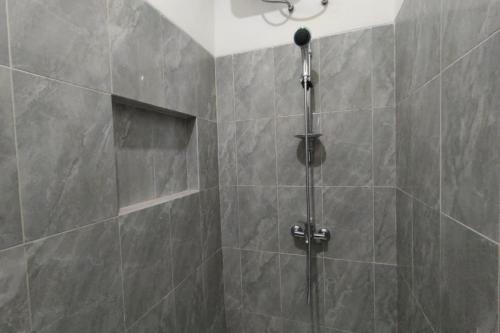 a shower with a glass door in a bathroom at RedDoorz near Rita Super Mall Purwokerto in Purwokerto