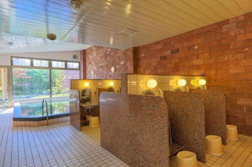 a bathroom with two stalls in a brick wall at Fuji Matsuzono Hotel in Yamanakako